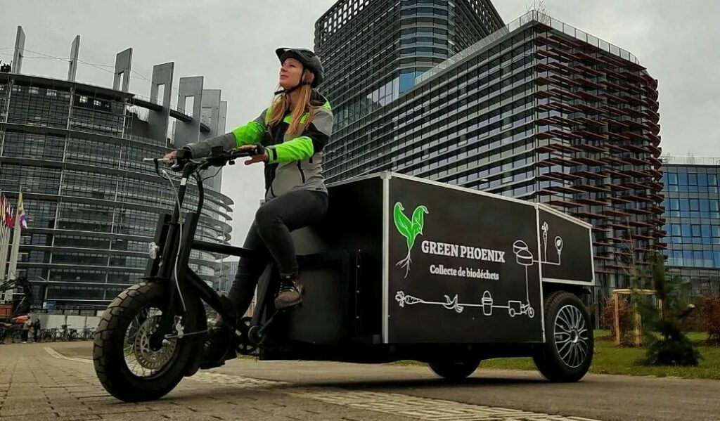 Équipière de collecte ramassant des biodéchets à vélo-cargo